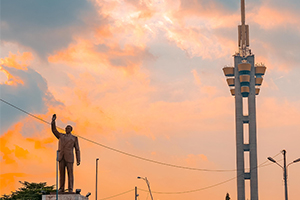 La statue de Patrice Lumumba et la tour de l'Échangeur de Limete au coucher du soleil