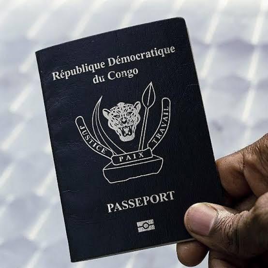 Une main tient un passeport de la République démocratique du Congo